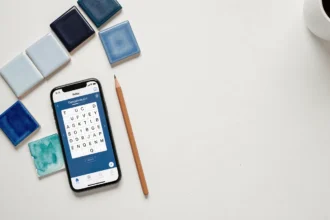 Vue à plat d'objets bleutés variés autour d'un jeu de mots sur smartphone, évoquant le thème des nuances de bleu